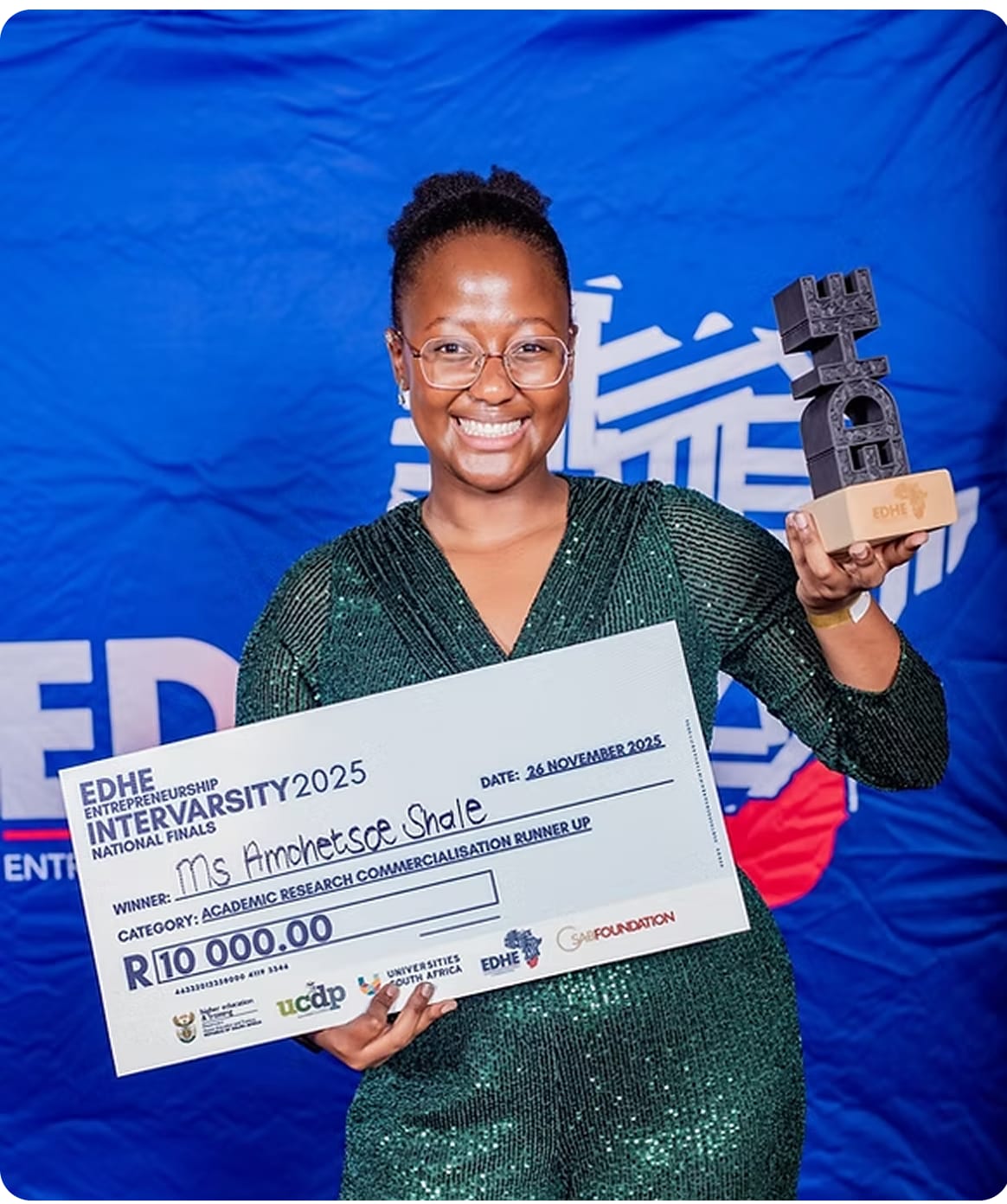 Amo Shale holding the EDHE Intervarsity trophy and an award cheque